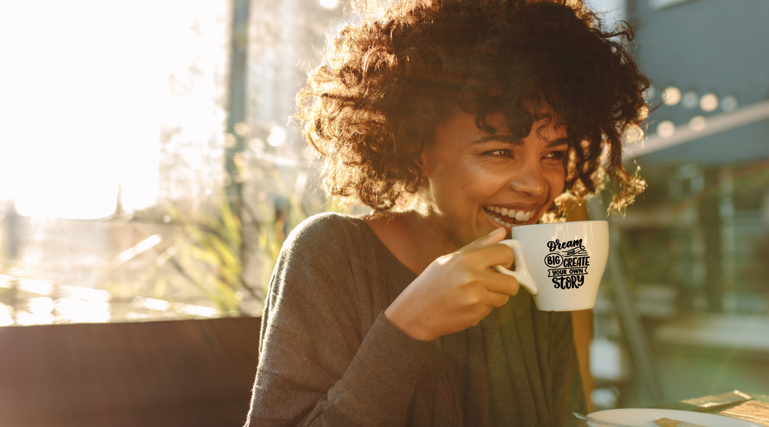 A woman sipping coffee from a mug featuring an inspiring and motivational message. This image highlights how a positive message can enhance her morning routine and set a cheerful tone for the day.